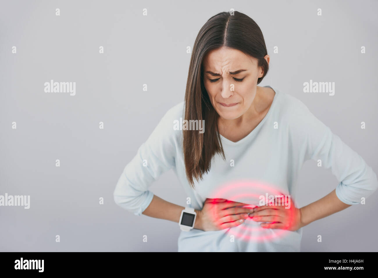 Suffering young woman filling pain in her stomach Stock Photo Alamy