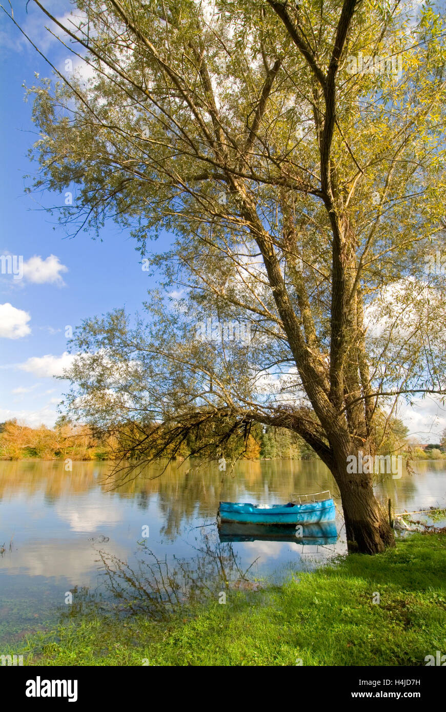 Tranquil autumnal Dordogne river scene with fishing boat on the rive gauche near Castillon Gironde South West France Stock Photo