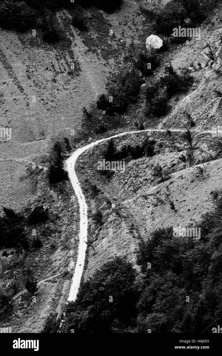 Curvy mountain path with big round stone Stock Photo