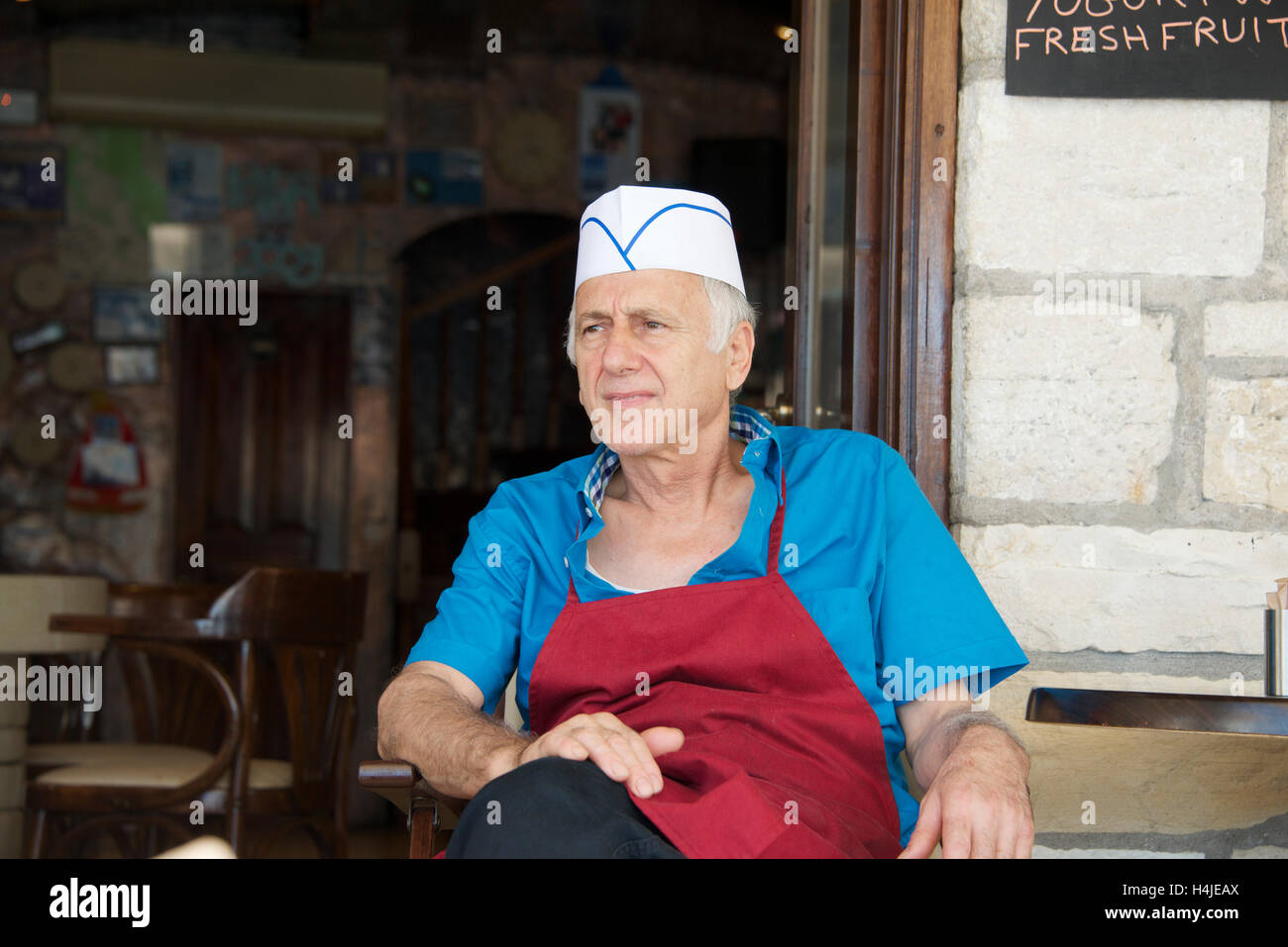 Chef relaxing outside taverna Lakka Paxos Ionian Islands Greece Stock Photo