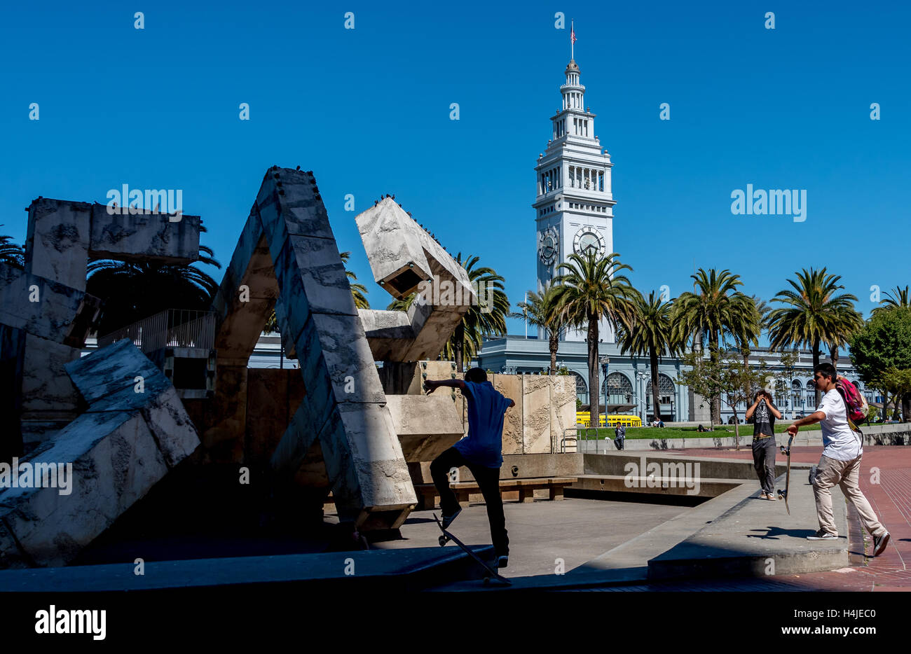 Skateboarders at Vaillancourt Fountain at Justin Herman Plaza at the Embarcadero with San Francisco Ferry Building in background Stock Photo