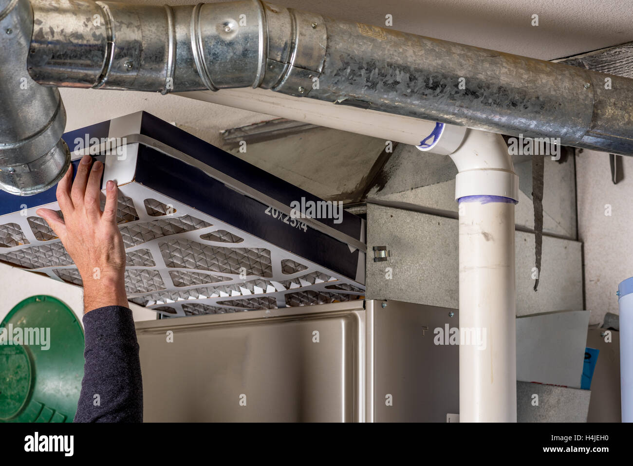 Handyman replaces a furnace filter with a clean one Stock Photo