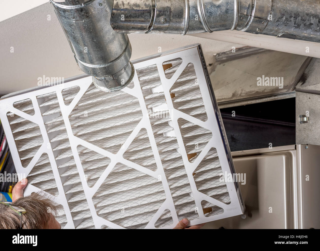Handyman inspects a filter from a home furnace Stock Photo