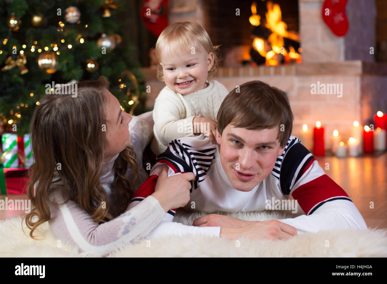 christmas, x-mas, family, people, happiness concept - happy parents playing with pretty baby Stock Photo