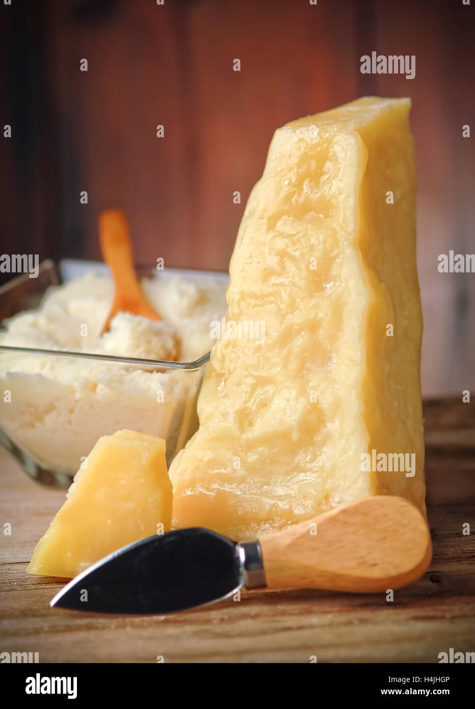 Slice of Italian parmesan cheese on wooden table Stock Photo