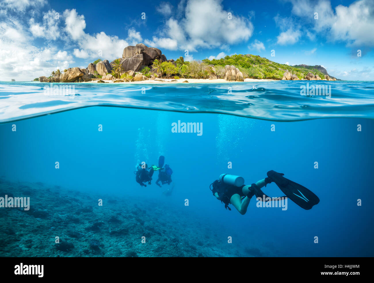 Divers below the surface in Seychelles exploring corlas Stock Photo