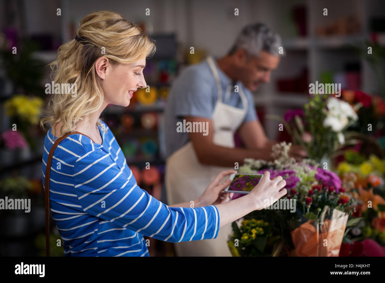 Woman taking photograph of flower bouquet Stock Photo
