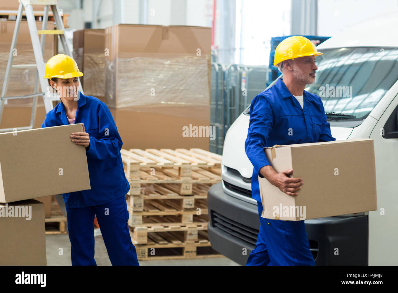 Delivery workers unloading cardboard boxes from pallet jack Stock Photo