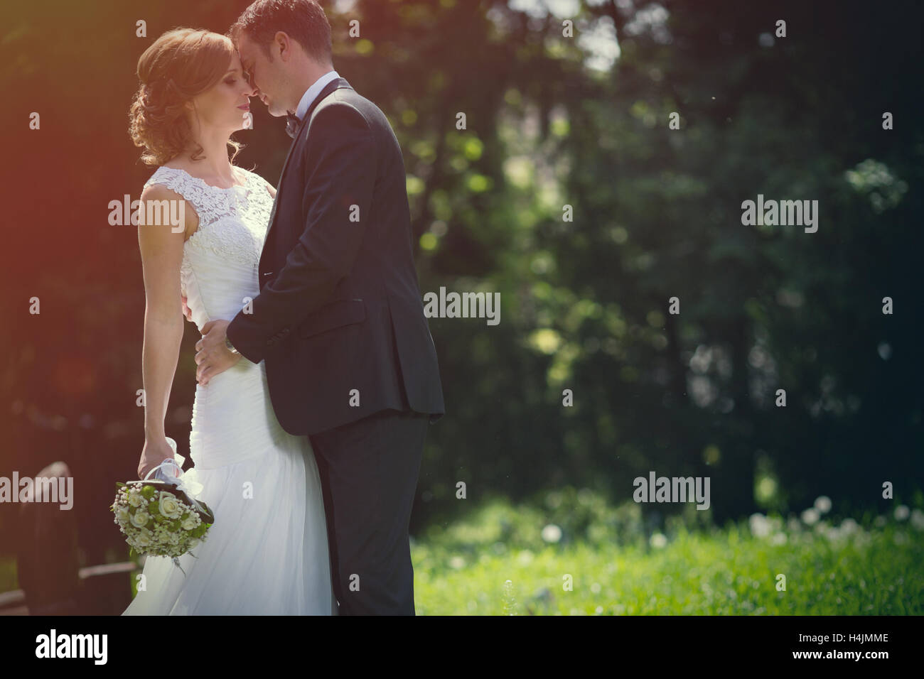 Beautiful bride and groom kissing outdoors Stock Photo - Alamy