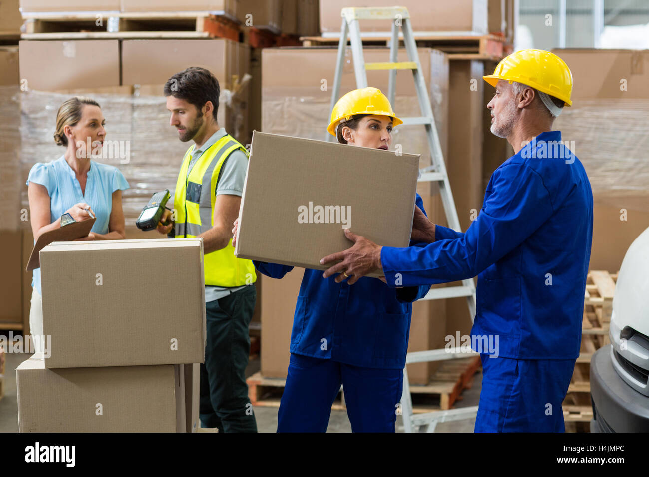 Delivery worker unloading cardboard boxes from pallet jack Stock Photo