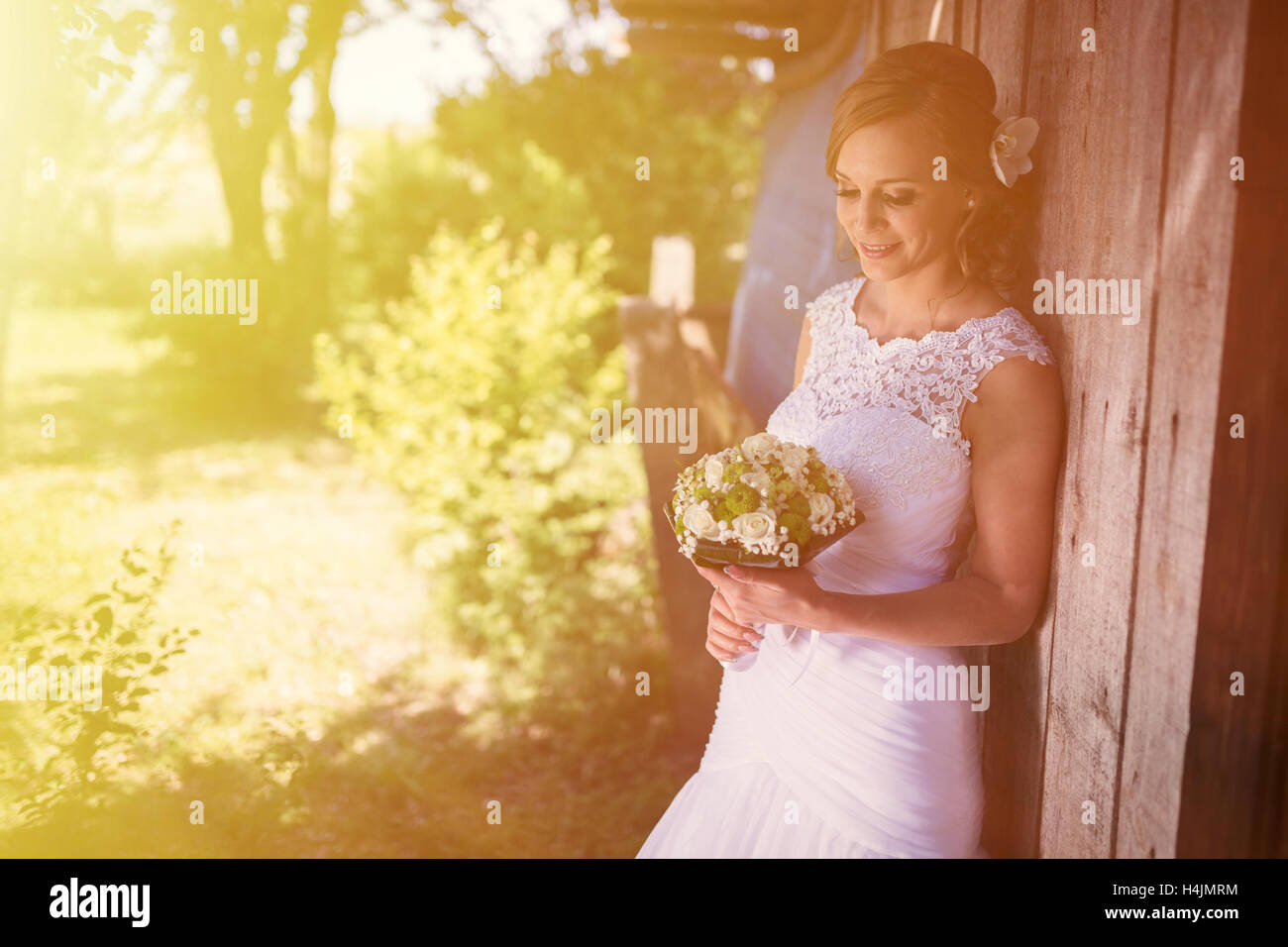 Beautiful bride posing outdoors with bouquet in hand Stock Photo - Alamy
