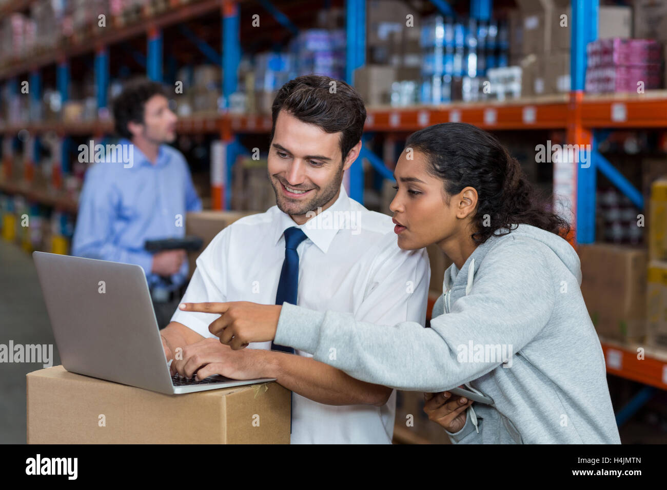 Warehouse worker working on laptop Stock Photo Alamy