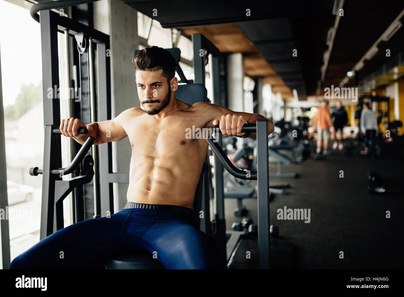 Determined bodybuilder working out in gym Stock Photo