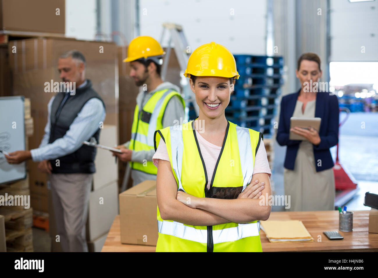 Portrait of female warehouse worker standing with arms crossed Stock Photo