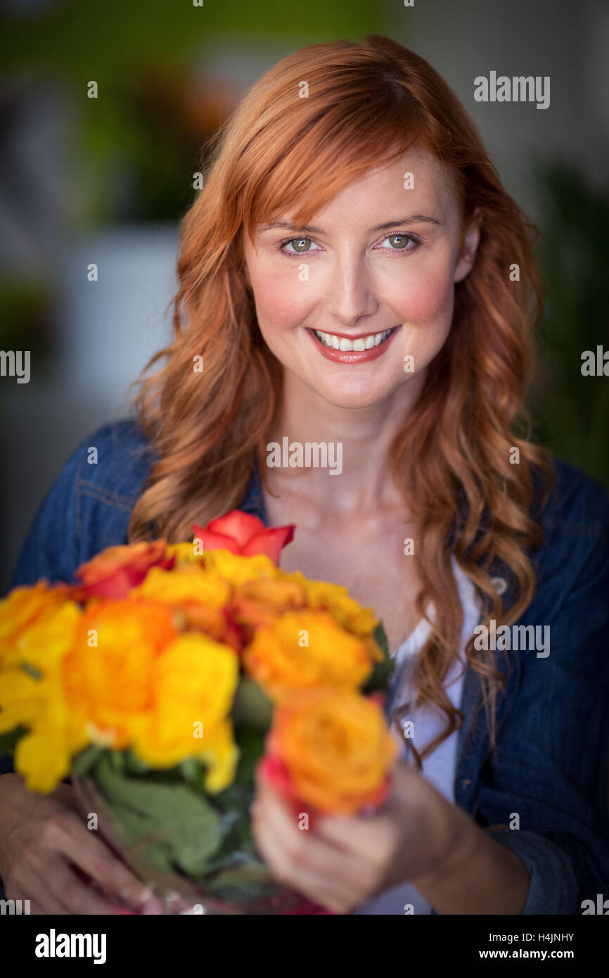 Portrait of female florist holding bunch of flowers Stock Photo