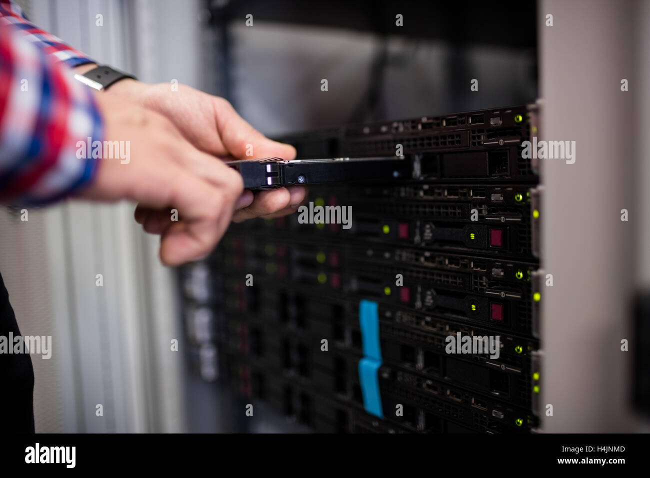 Technician inserting a hard disk drive into a blade server Stock Photo