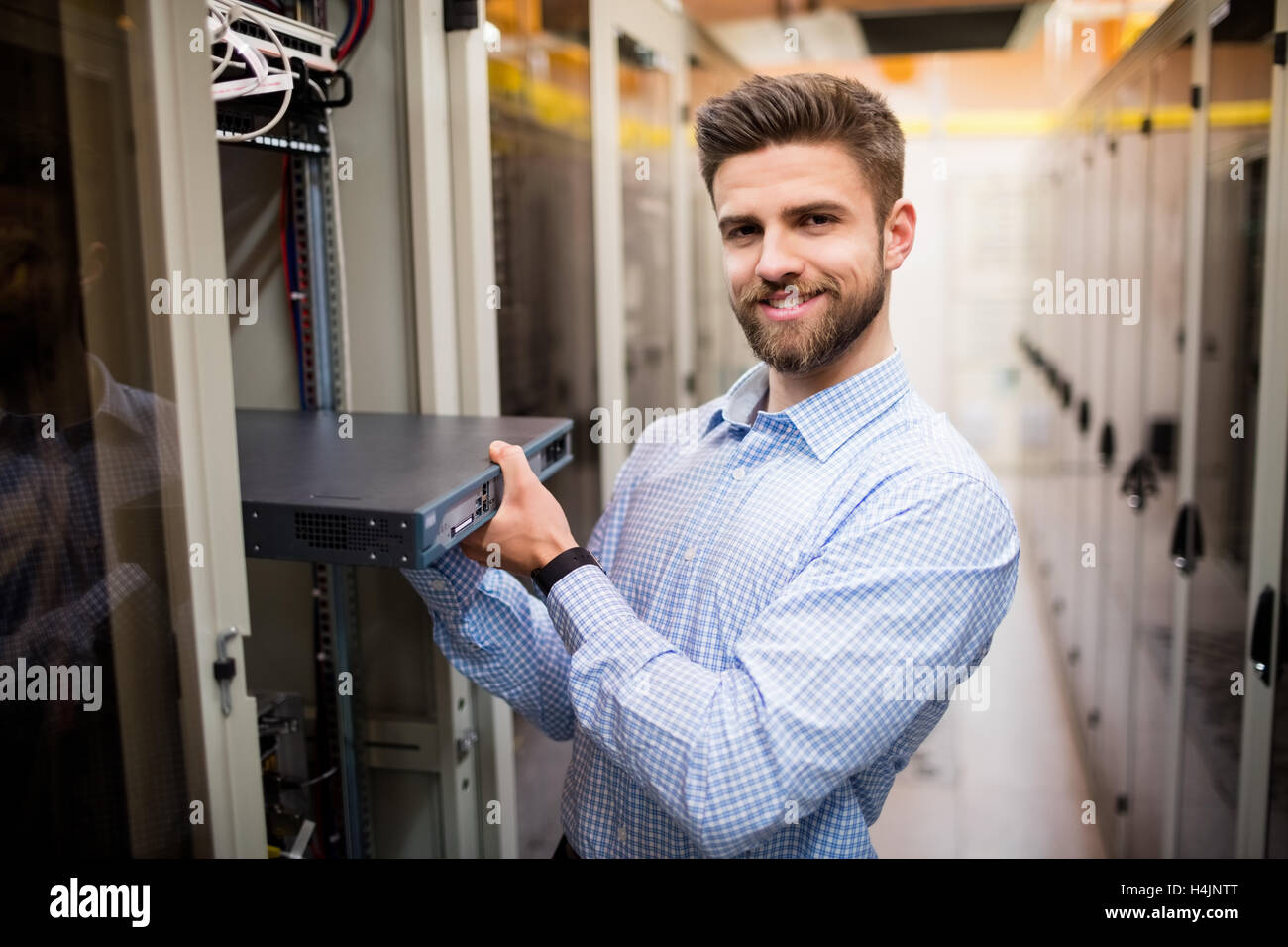 Technician removing server from rack mounted server Stock Photo