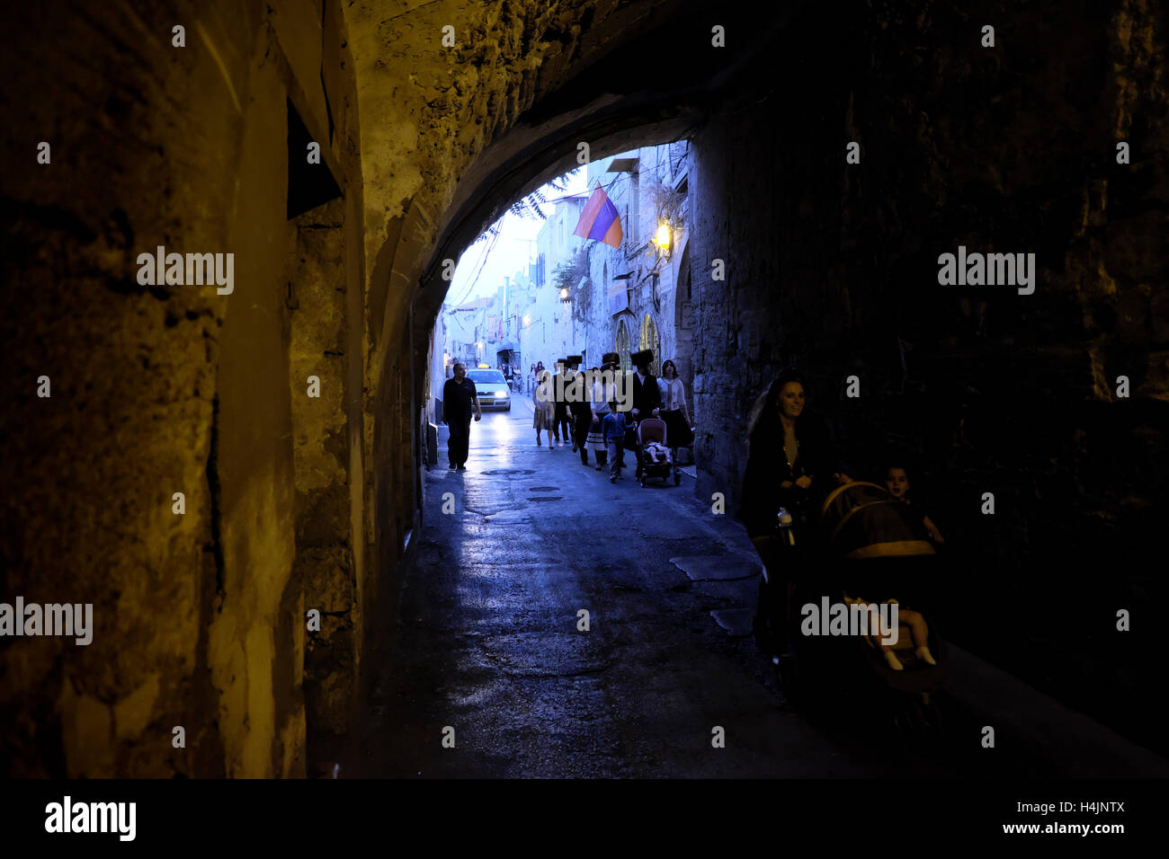 Ultra Orthodox Jews walking along the Armenian Patriarchate street in the Armenian quarter in the old city of East Jerusalem Israel Stock Photo