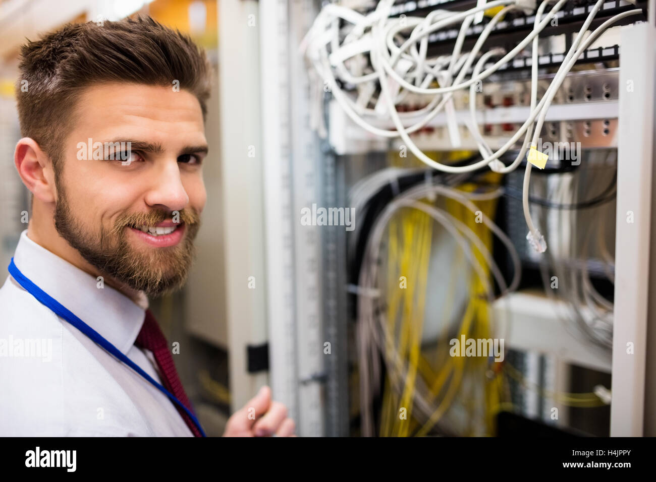 Smiling technician standing in a server room Stock Photo Alamy