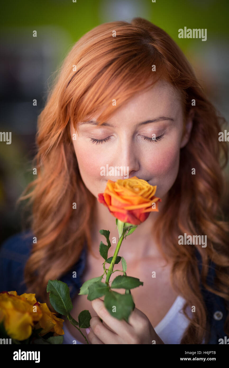Female florist smelling a rose flower Stock Photo Alamy