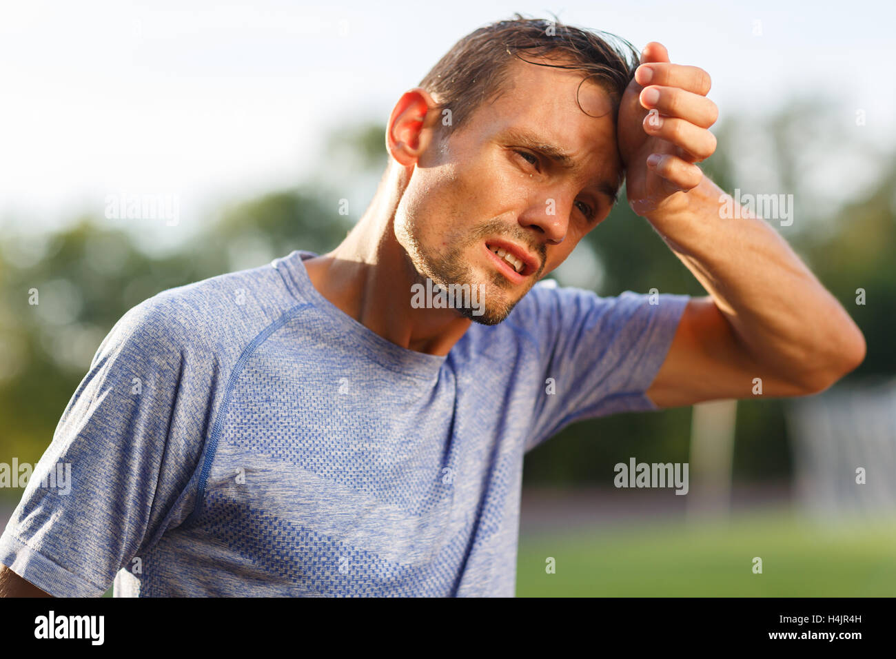 Tired exercise and heat sporty man wiping sweat from face Stock Photo Alamy