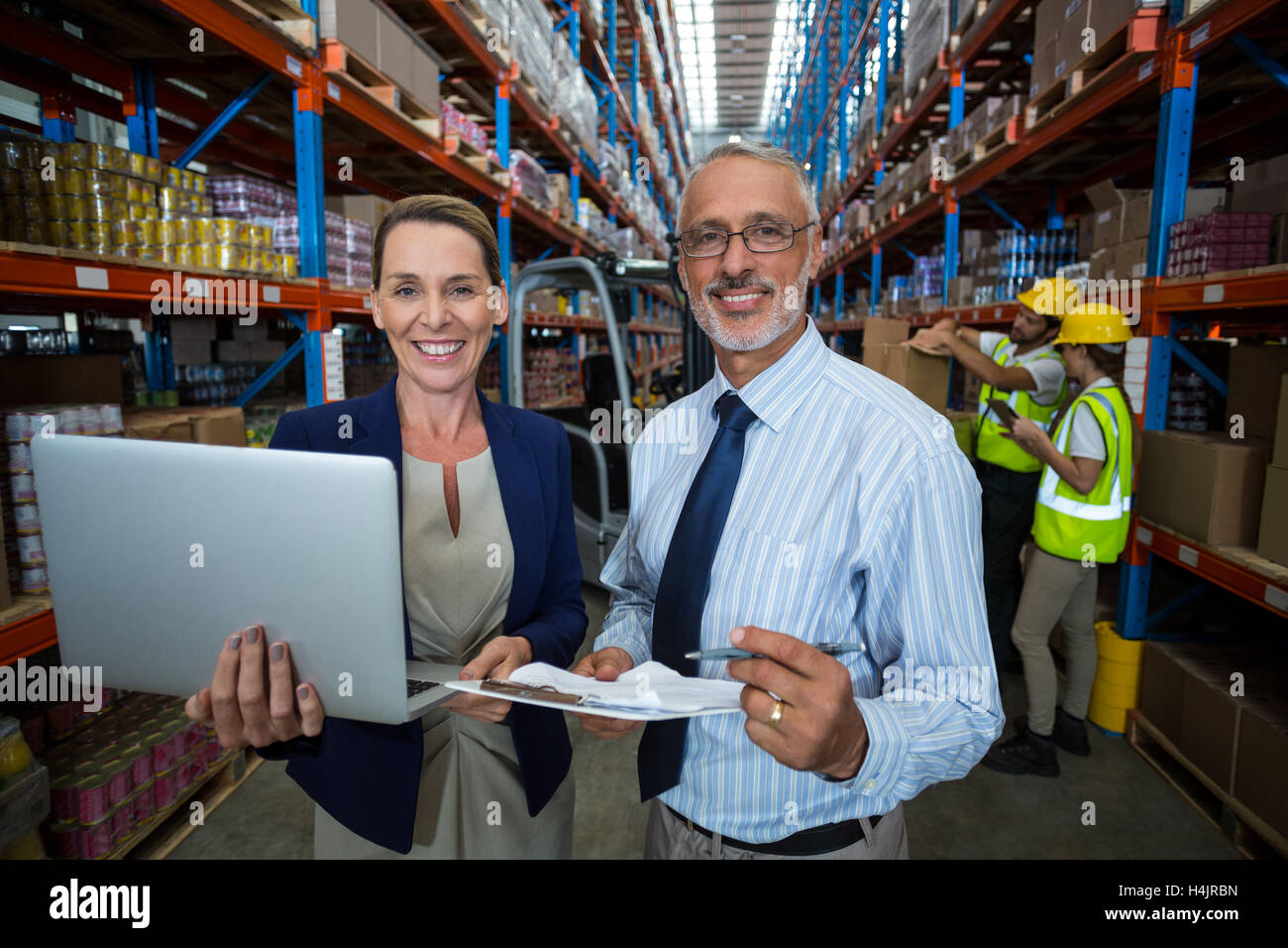 Warehouse manager and client holding digital tablet and clipboard Stock Photo