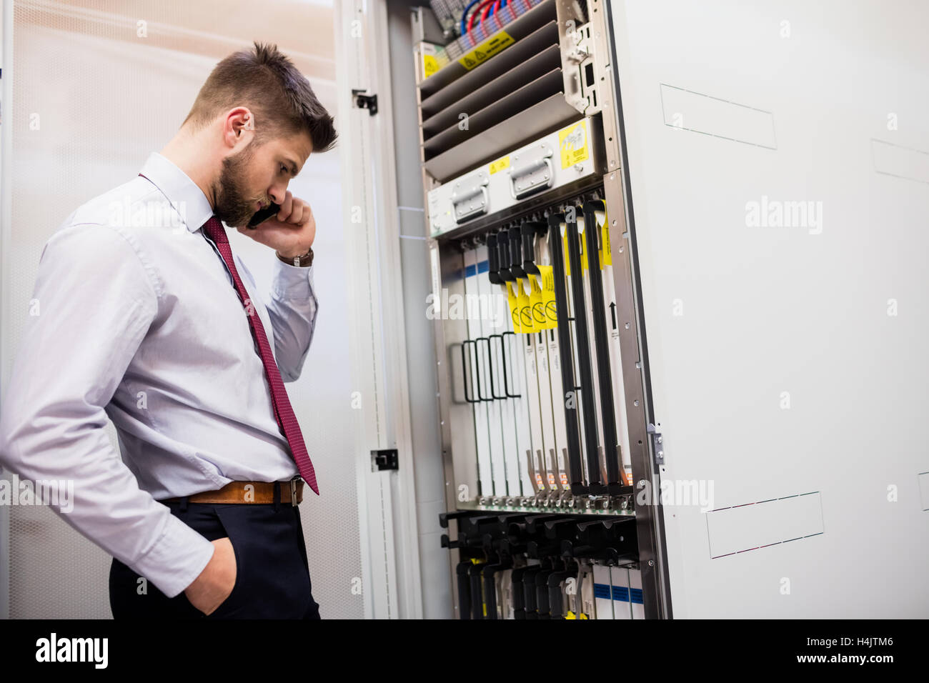 Technician talking on mobile phone in server room Stock Photo Alamy