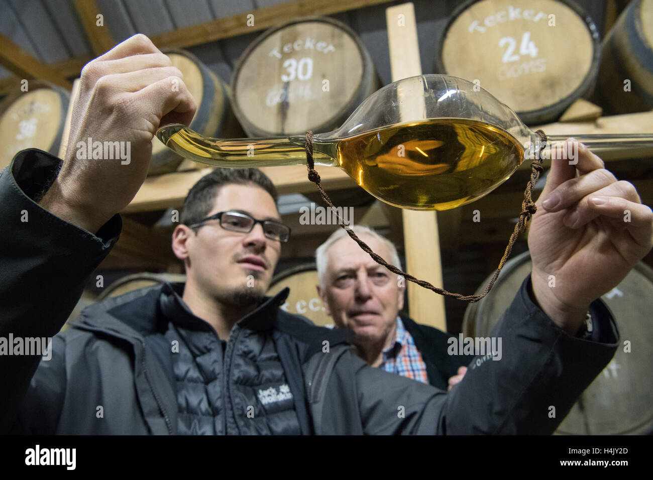 Owen, Germany. 13th Oct, 2016. Christian Gruel (r) and his grandson Immanuel Gruel look at a whisky-lifter in the whisky barrel cellar of spirits distillery Gruel in Owen, Germany, 13 October 2016. PHOTO: MARIJAN MURAT/dpa/Alamy Live News Stock Photo