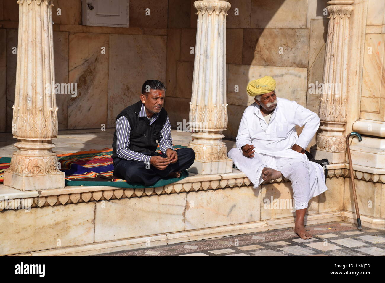 Two Indian men sitting outside Karni Mata rat temple in Deshnoke (Bikaner), Rajasthan, India Stock Photo