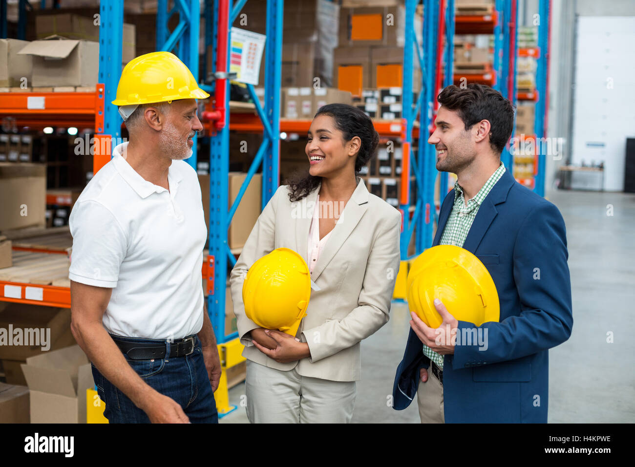 Happy warehouse managers and worker standing together Stock Photo - Alamy