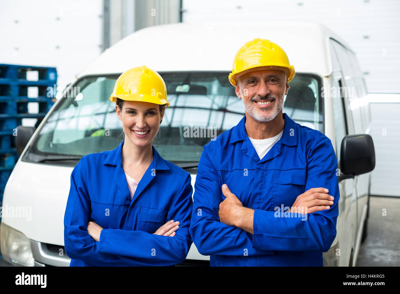 Portrait of warehouse workers standing together with arms crossed Stock Photo
