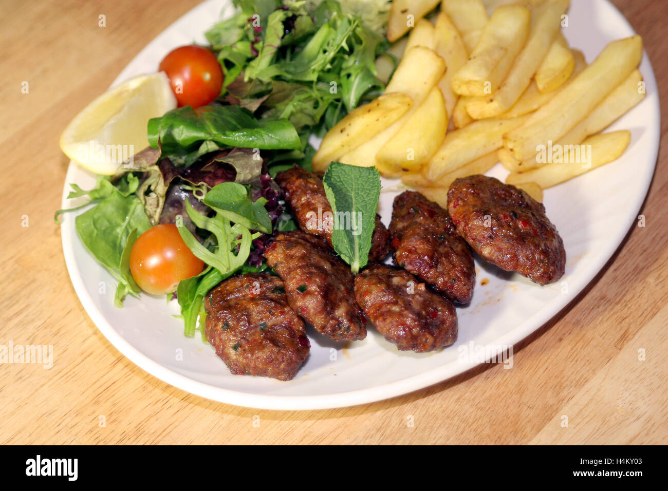 Grilled Meatball served with fries and salad Stock Photo