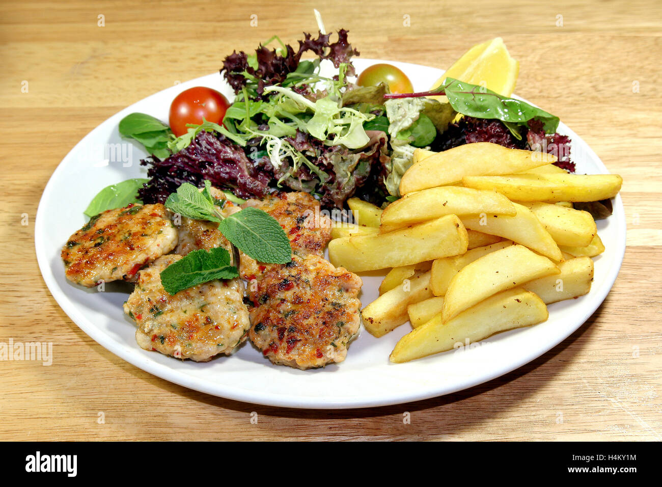 Grilled Chicken Meatball served with fries and salad Stock Photo