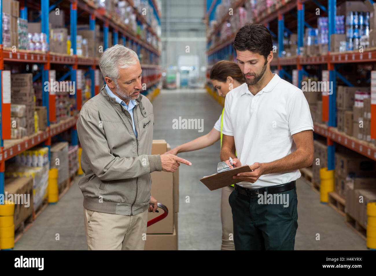 Warehouse manager and male worker interacting while working Stock Photo