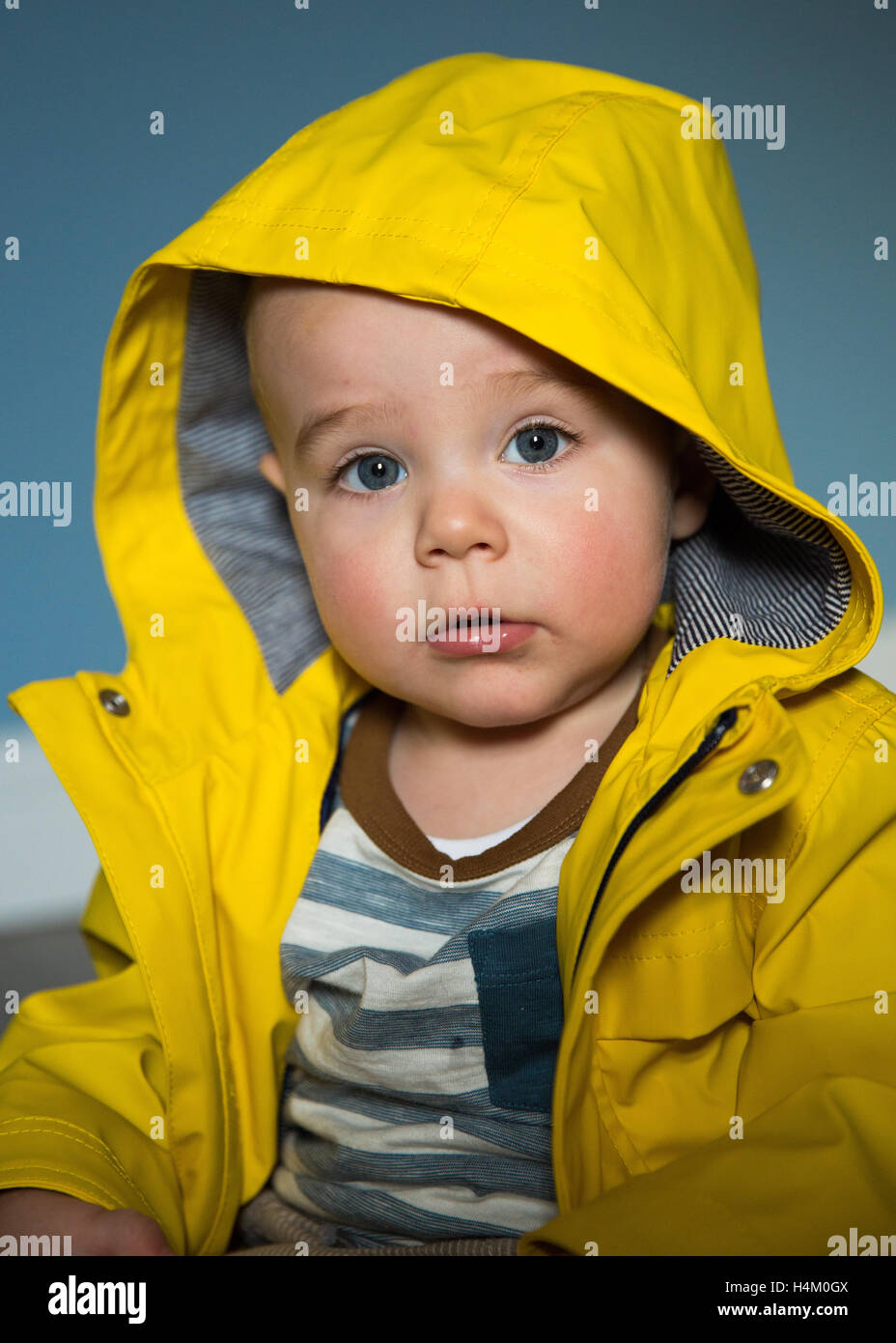 Little blue eye boy wearing a rain coat Stock Photo
