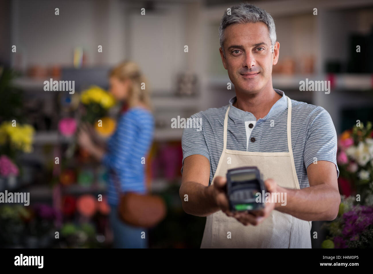 Florist showing credit card terminal in flower shop Stock Photo