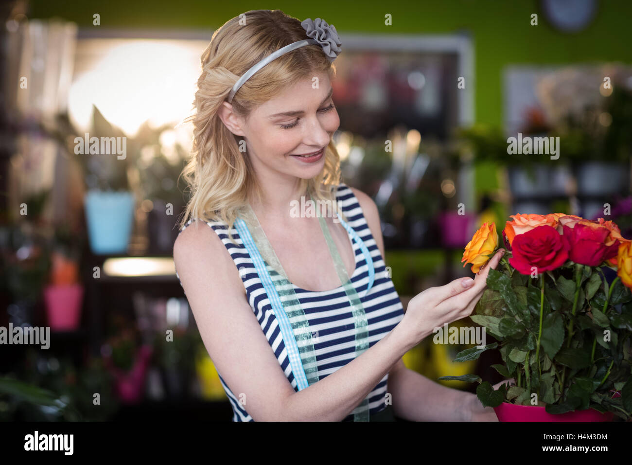Female florist touching rose flowers Stock Photo Alamy