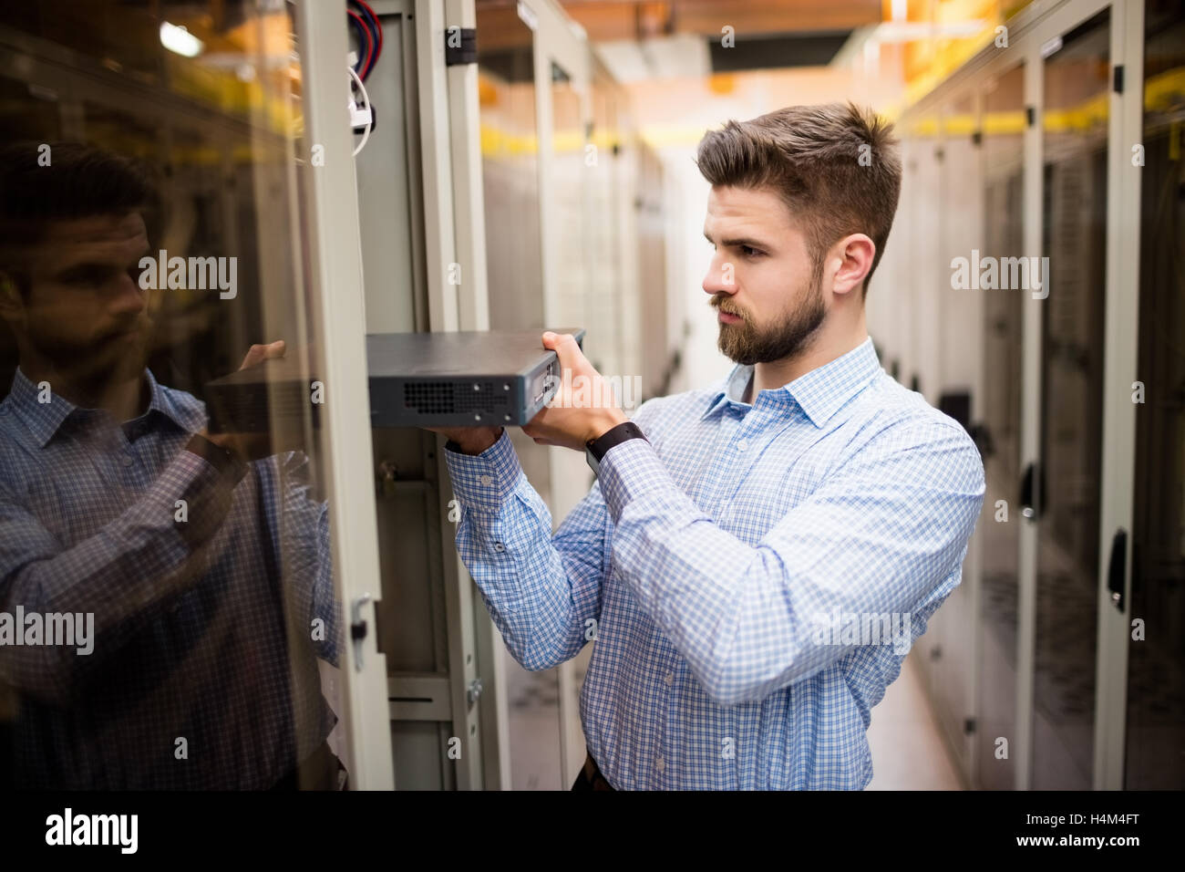 Technician removing server from rack mounted server Stock Photo
