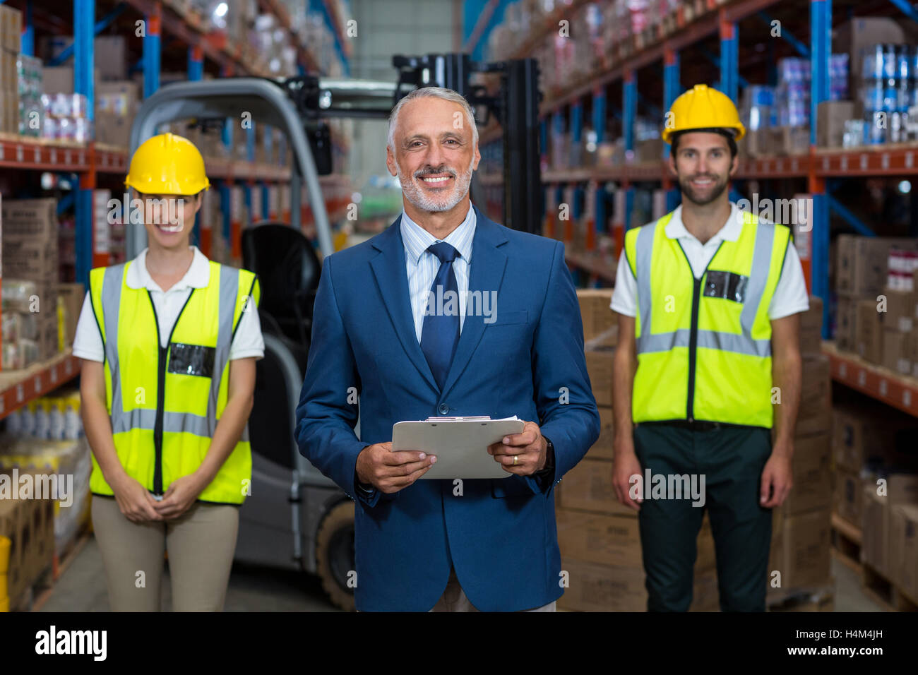 Portrait of warehouse manager and co-workers standing with clipboard Stock Photo