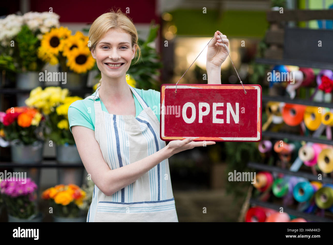 Female florist holding open signboard Stock Photo Alamy