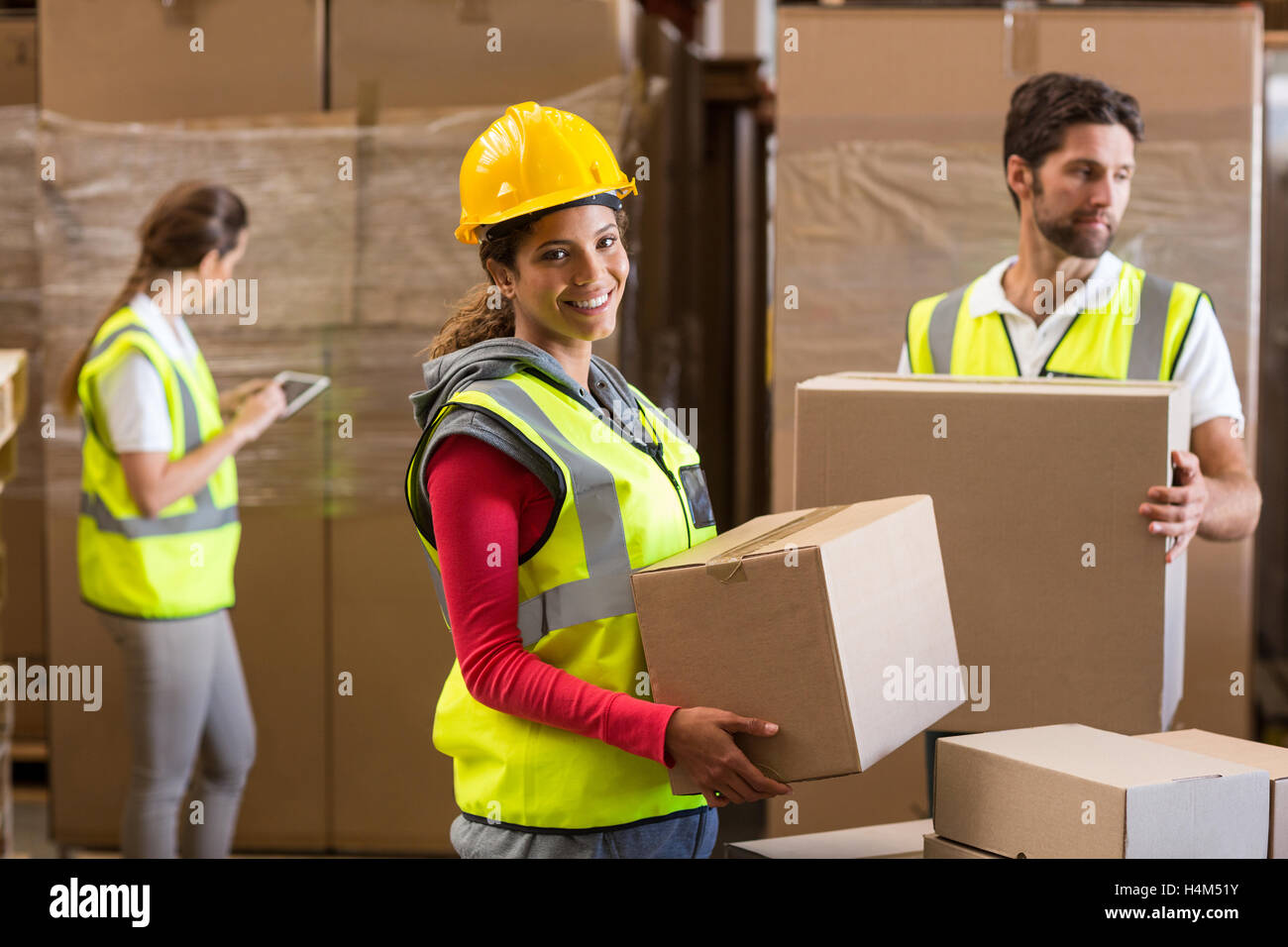 Portrait of warehouse worker carrying a cardboard box Stock Photo