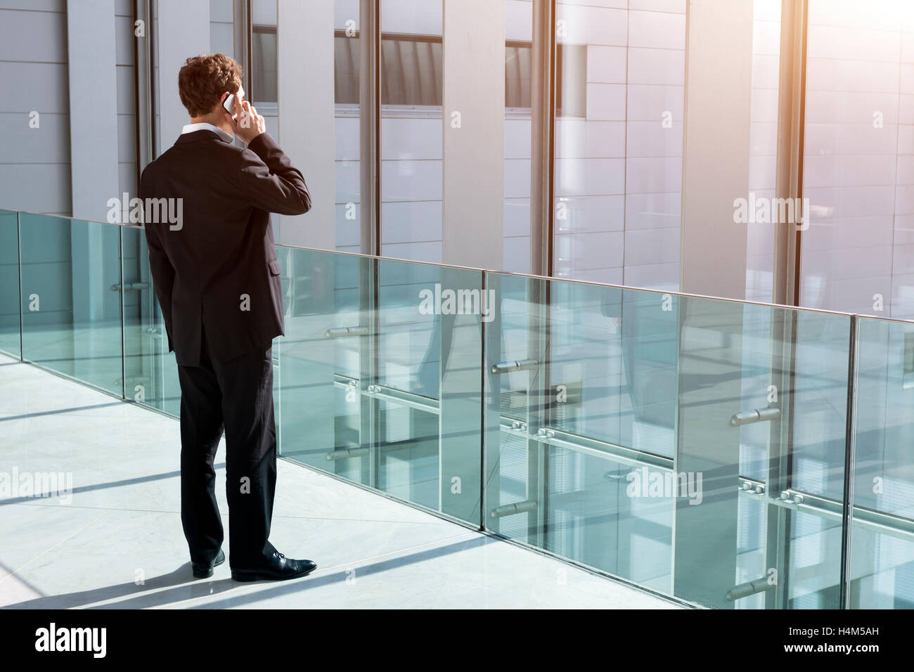Businessman taking a call on smartphone in office building Stock Photo