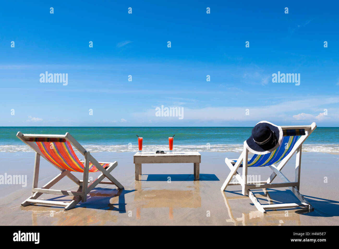 Leisure on the beach, two deckchairs with cocktail and sunglasses, sunny summer day Stock Photo