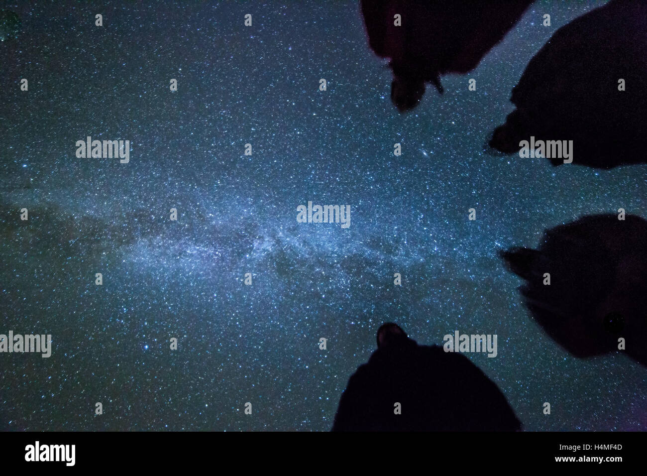 Silhouettes of 4 men with the milky way Stock Photo