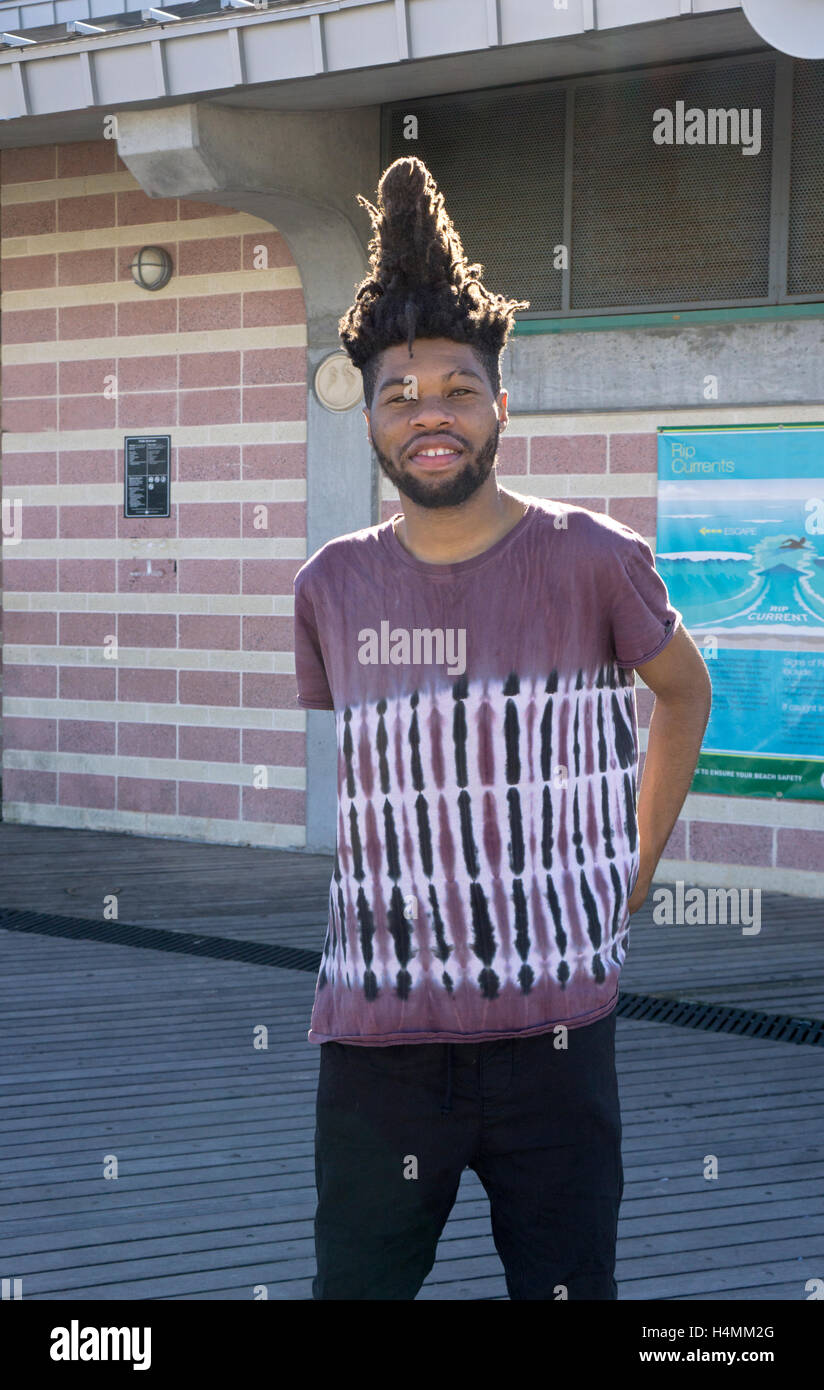 Portrait of an African American young man  with an unusual tower shaped hairdo. In Coney Island, Brooklyn, New York Stock Photo