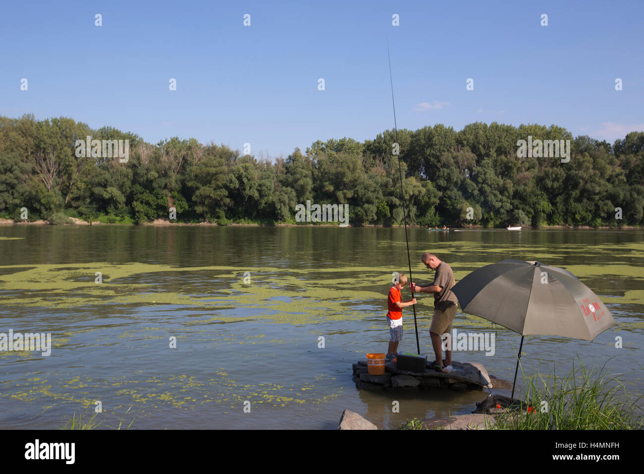 People fishing on the banks of the River Tisza, one of the main rivers in Central Europe which runs through Szeged, Hungary Stock Photo
