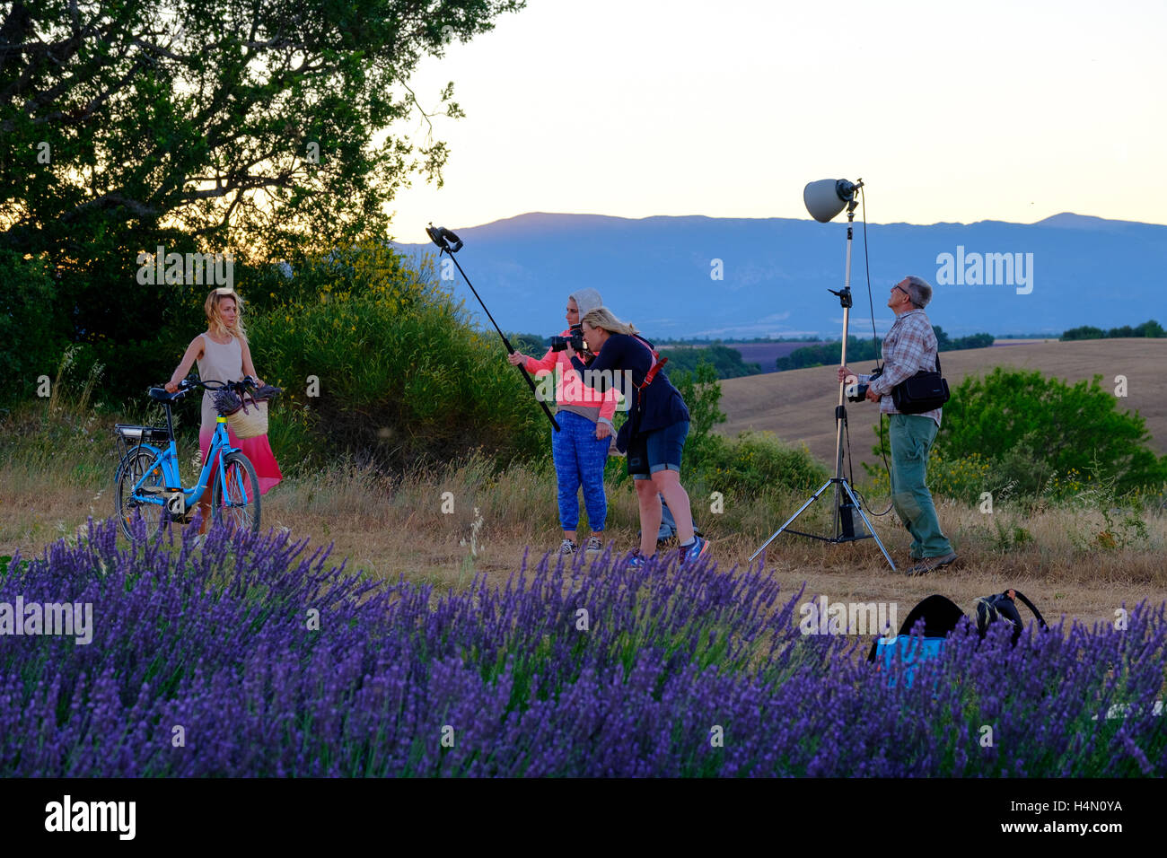 Photographer and lighting assistant taking pictures of a young woman