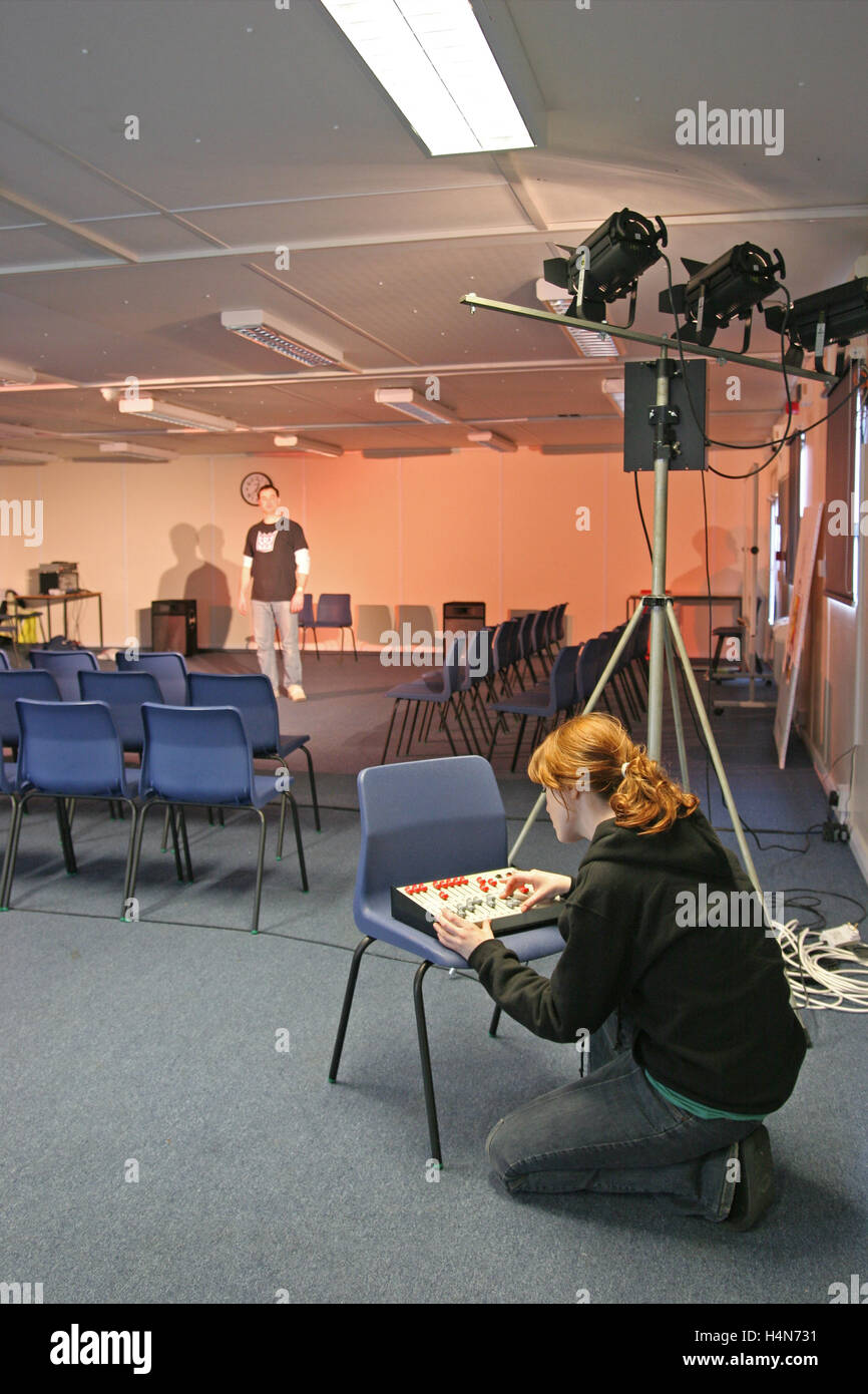 A student operates theatre lighting in a school drama studio. Shows dimmer and spotlights Stock Photo