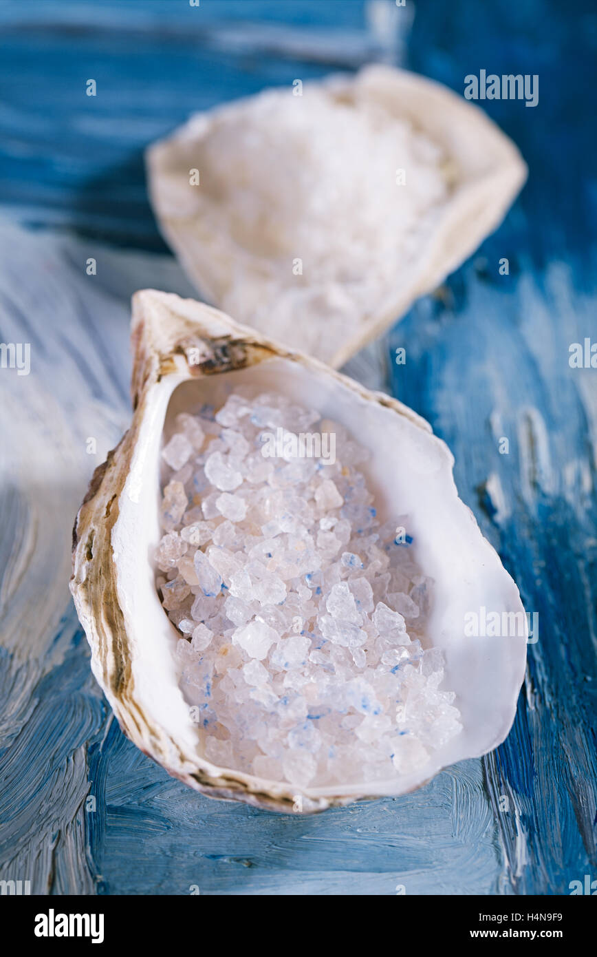 Blue persian sea salt in sea shell oyster on blue abstract painted