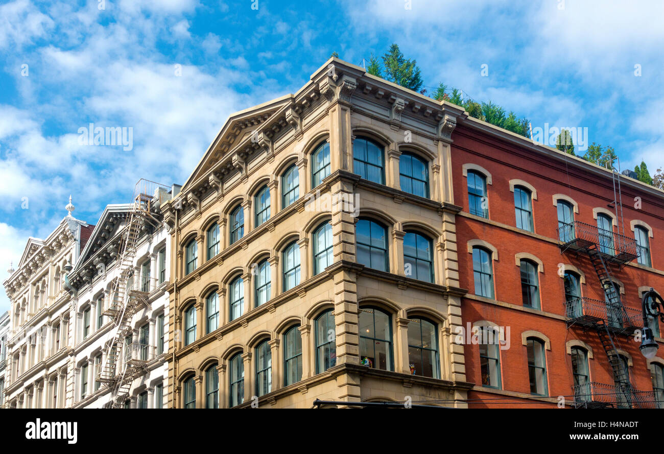 Cast-iron architecture buildings in Soho in New York City, with trees on roof suggesting NYC penthouse apartment living Stock Photo